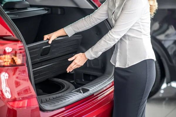 Mãos das mulheres mostrando carro dispositivo tronco aberto — Fotografia de Stock