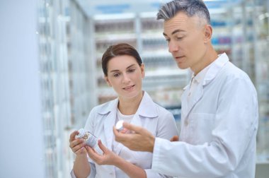 Kadın ve adam beyaz önlüklü ve ilaçlı