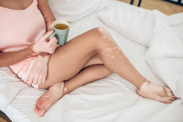 Una mujer tomando café por la mañana mientras está acostada en la cama —  Fotos de Stock