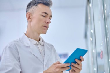 Tabletteki bilgileri inceleyen konsantre adam