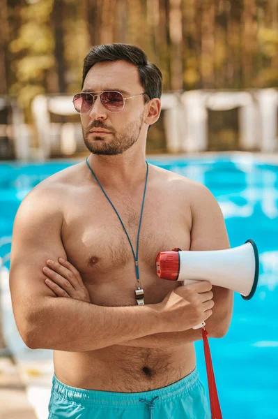 Male lifeguard in sunglasses near the public swimming pool — Stock Photo, Image