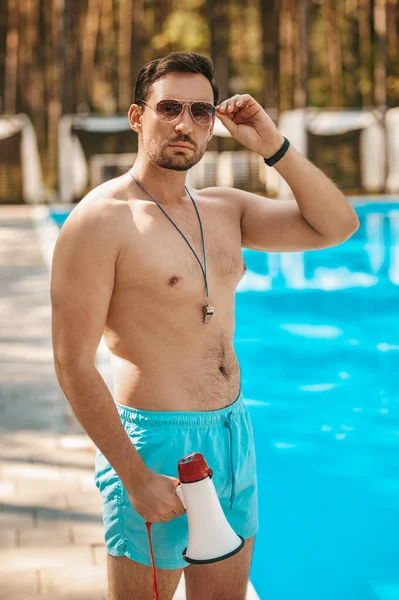 Salvavidas masculino en gafas de sol cerca de la piscina pública —  Fotos de Stock