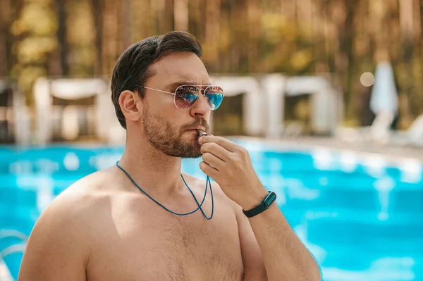 Männlicher Bademeister mit Sonnenbrille in der Nähe des Freibades — Stockfoto