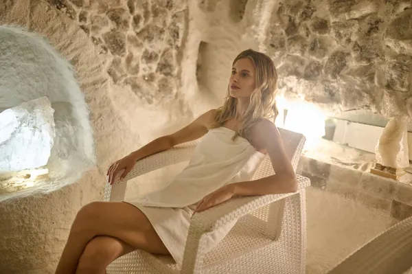 A young blonde woman having a breathe session in a salt room — Stock Photo, Image