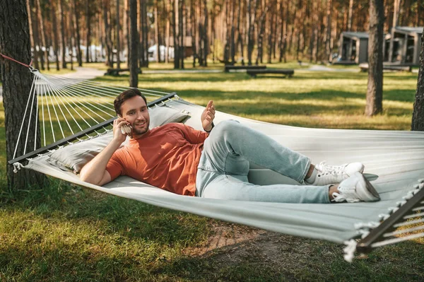 Man with smartphone relaxing in hammock — Stock Photo, Image