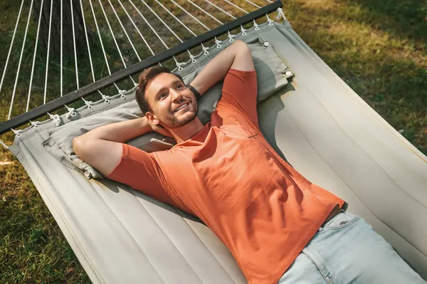 Glücklicher Mann, der auf Hängematte in der Natur liegt — Stockfoto