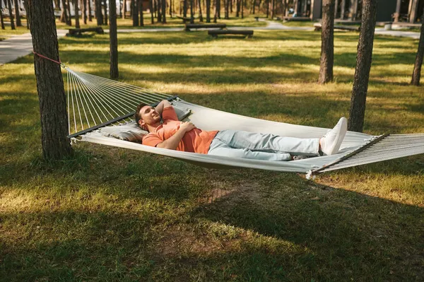 Man with closed eyes lying in hammock in nature — Stock Photo, Image
