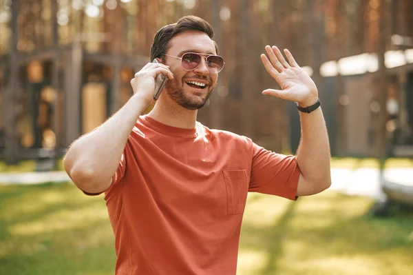 Muž mluví na smartphonu přátelsky gestikuluje — Stock fotografie