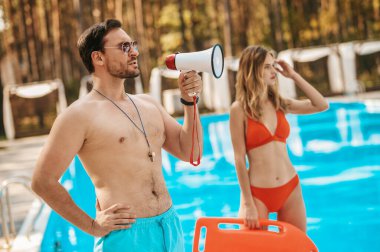 İki havuz cankurtaranı halka açık havuzun yanında duruyor.