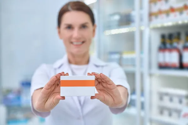 Mulheres farmacêuticas mãos mostrando caixa de remédio — Fotografia de Stock