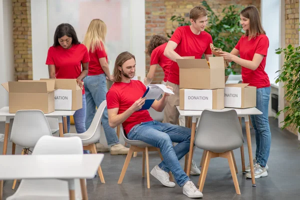 Volontari che lavorano in un punto di smistamento e sembrano impegnati — Foto Stock