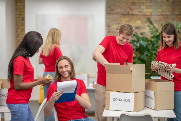 Volontärer som arbetar i en sorteringspunkt och ser upptagna ut — Stockfoto