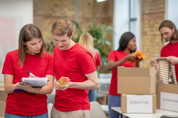 Freiwillige, die in einer Sortierstelle arbeiten und beschäftigt sind — Stockfoto