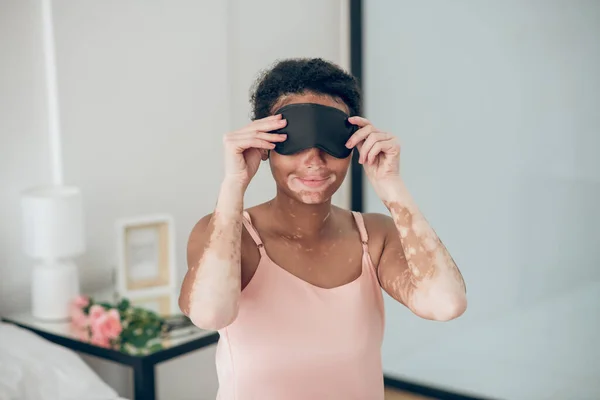 Uma jovem mulher vestindo uma máscara de dormir — Fotografia de Stock