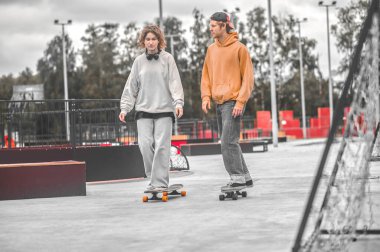 Adam ve kız kaykaylarda yavaş yavaş konuşuyorlar.