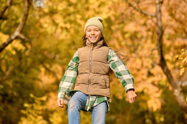 A girl in warm clothes playing in the park — Stock Photo, Image
