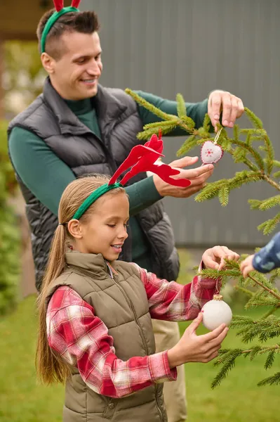 Een gezin decoratie een nieuw jaar boom samen en kijkend opgewonden — Stockfoto