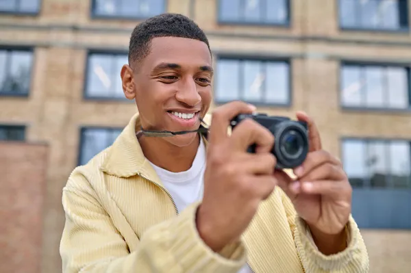 Fotógrafo en ropa beige revisando las tomas — Foto de Stock