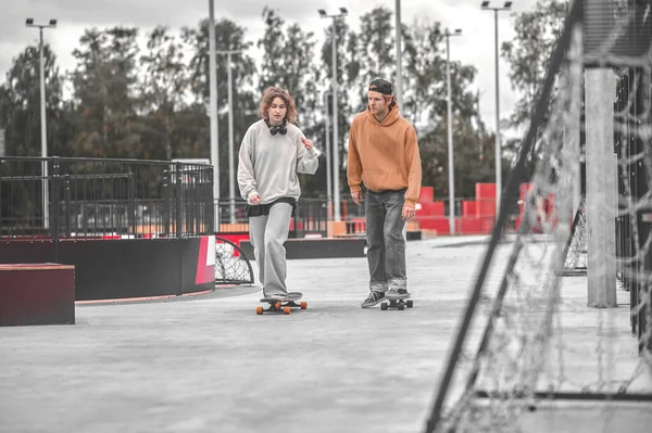 Guy et fille skateboard communiquer dans le parc — Photo