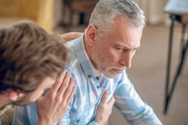 Médico geriátrico atendiendo a un enfermo triste — Foto de Stock