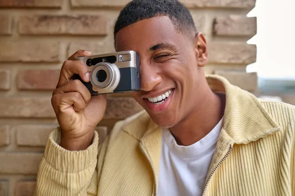 Gülümseyen genç erkek fotoğrafçı kendini iyi ve mutlu hissediyor. — Stok fotoğraf
