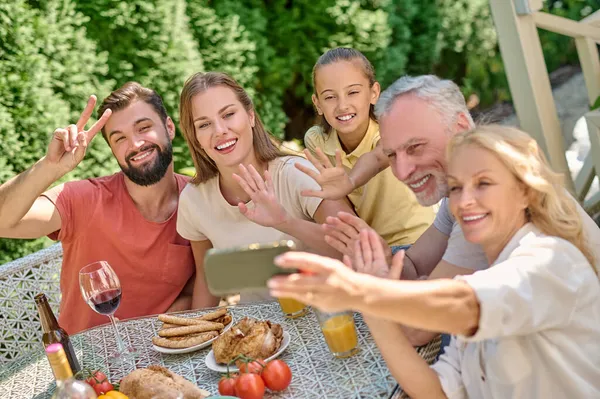 Семья, сидящая за обеденным столом и выглядящая радостно — стоковое фото