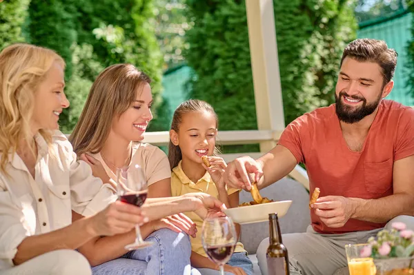 Uma família sorridente sentada à mesa de jantar — Fotografia de Stock