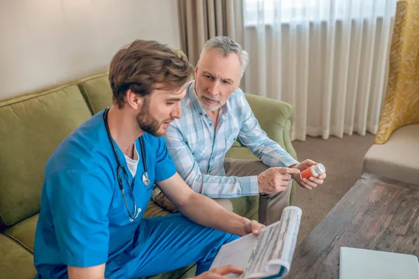 Paciente discutiendo la prescripción de un nuevo medicamento con su médico — Foto de Stock