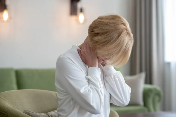 Mulher loira sentindo-se mal enquanto sofre de dor no pescoço — Fotografia de Stock