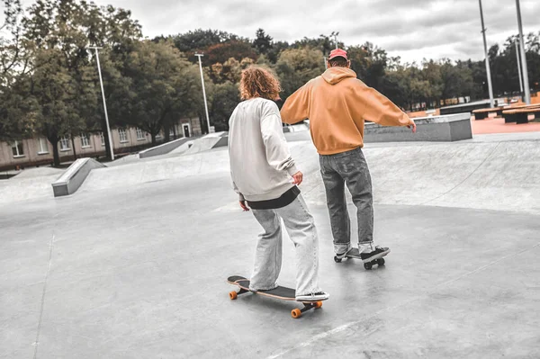 Vista posteriore di ragazzo e ragazza scorrevole su skateboard — Foto Stock