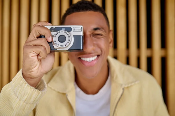 Männlicher Fotograf sitzt und hält Kamera in den Händen — Stockfoto