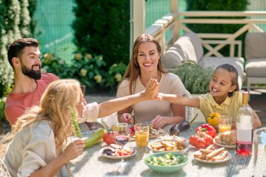 Masada oturup yemek yiyen bir aile.