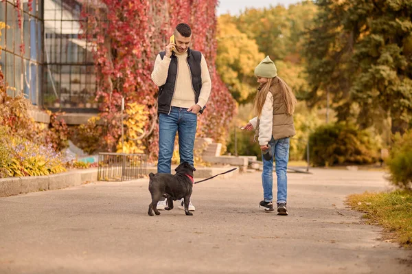 Un homme et sa fille sur na promenade avec leur chien — Photo