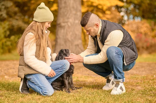 Egy család együtt tölti az idejét a parkban a kutyájával. — Stock Fotó