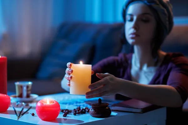 Focused female fortune-teller cleansing her divination table — Stock Photo, Image