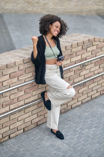 Snygg ung kvinna nesr browck väggen poserar och ler — Stockfoto
