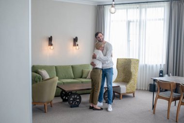 Genç bir adam annesini ziyaret ediyor ve mutlu görünüyor.