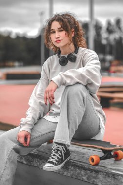 kaykay parkı üzerinde oturan kız