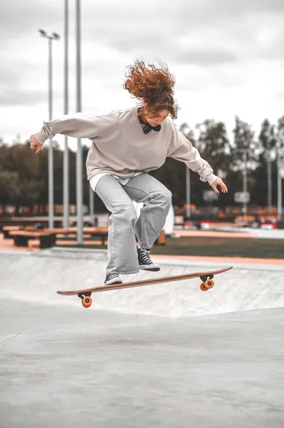 Mädchen springt im Moment auf Skateboard — Stockfoto