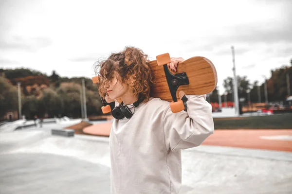 Προφίλ του κοριτσιού που κρατά skeetboard στους ώμους της — Φωτογραφία Αρχείου