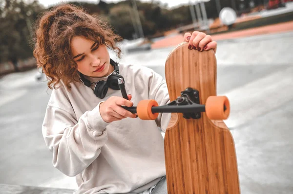 Κορίτσι ρυθμίζοντας τροχό στο skateboard — Φωτογραφία Αρχείου