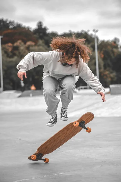 Mädchen springt im Moment über Skateboard — Stockfoto