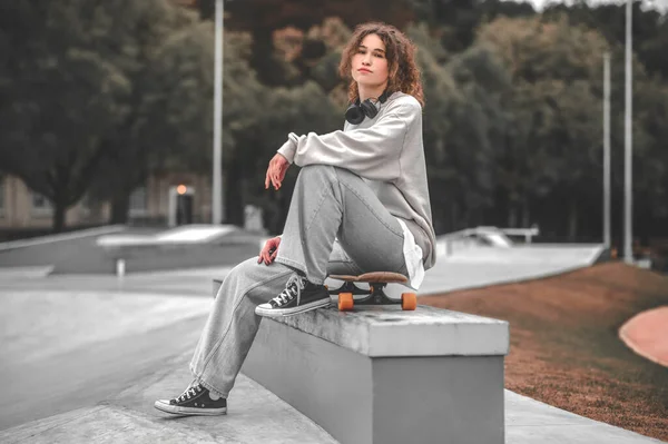 Κορίτσι που κάθεται στο skateboard στο σχήμα στο skatepark — Φωτογραφία Αρχείου