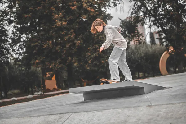 Mädchen auf Skateboard fährt auf Sprungbrett — Stockfoto