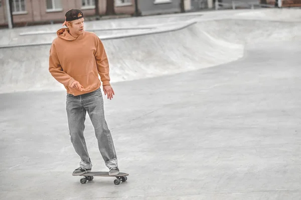 Mann mit Mütze fährt Skateboard im Park — Stockfoto