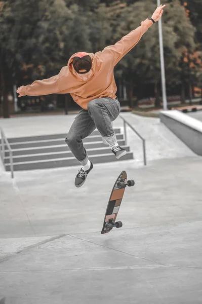 Guy studsar högt i luften och skateboard faller under — Stockfoto