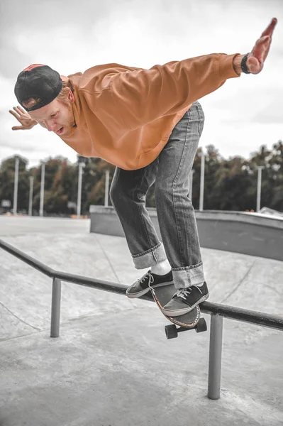 Guy on skateboard flying over railing in skatepark — Stock Photo, Image