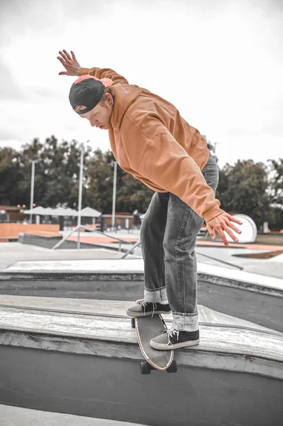Kerl auf Skateboard verliert das Gleichgewicht und rutscht am Bordstein entlang — Stockfoto