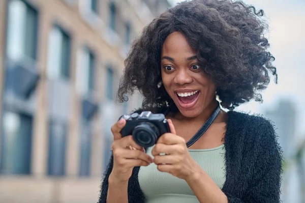 Ciemnoskóra młoda kobieta z kamerą na ulicy — Zdjęcie stockowe