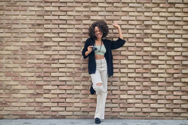 Dark-skinned young woman with camera in the street — Stock Photo, Image